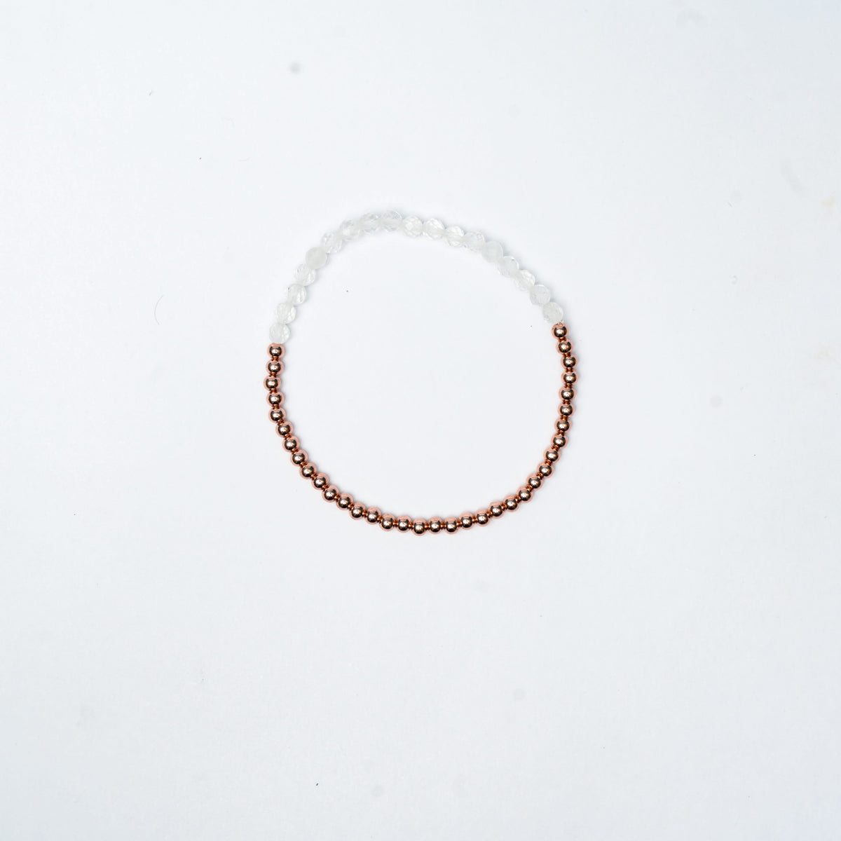 Stretch Bracelet with Clear Quartz beads, 3mm copper beads and elastic wire on a white 